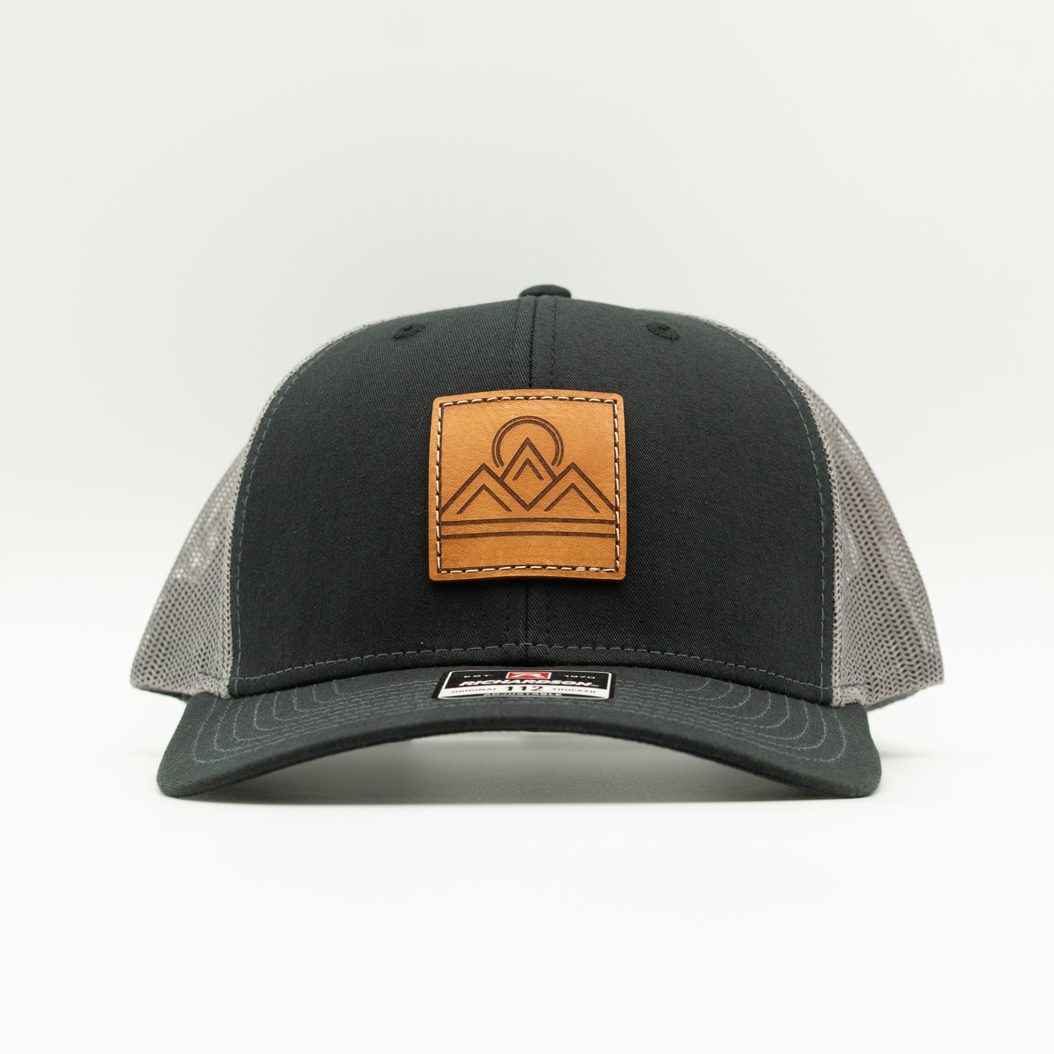 Front view of Lunar Ridge black and charcoal Richardson 112 trucker hat with square leather mountain patch

Color: Black/Charcoal