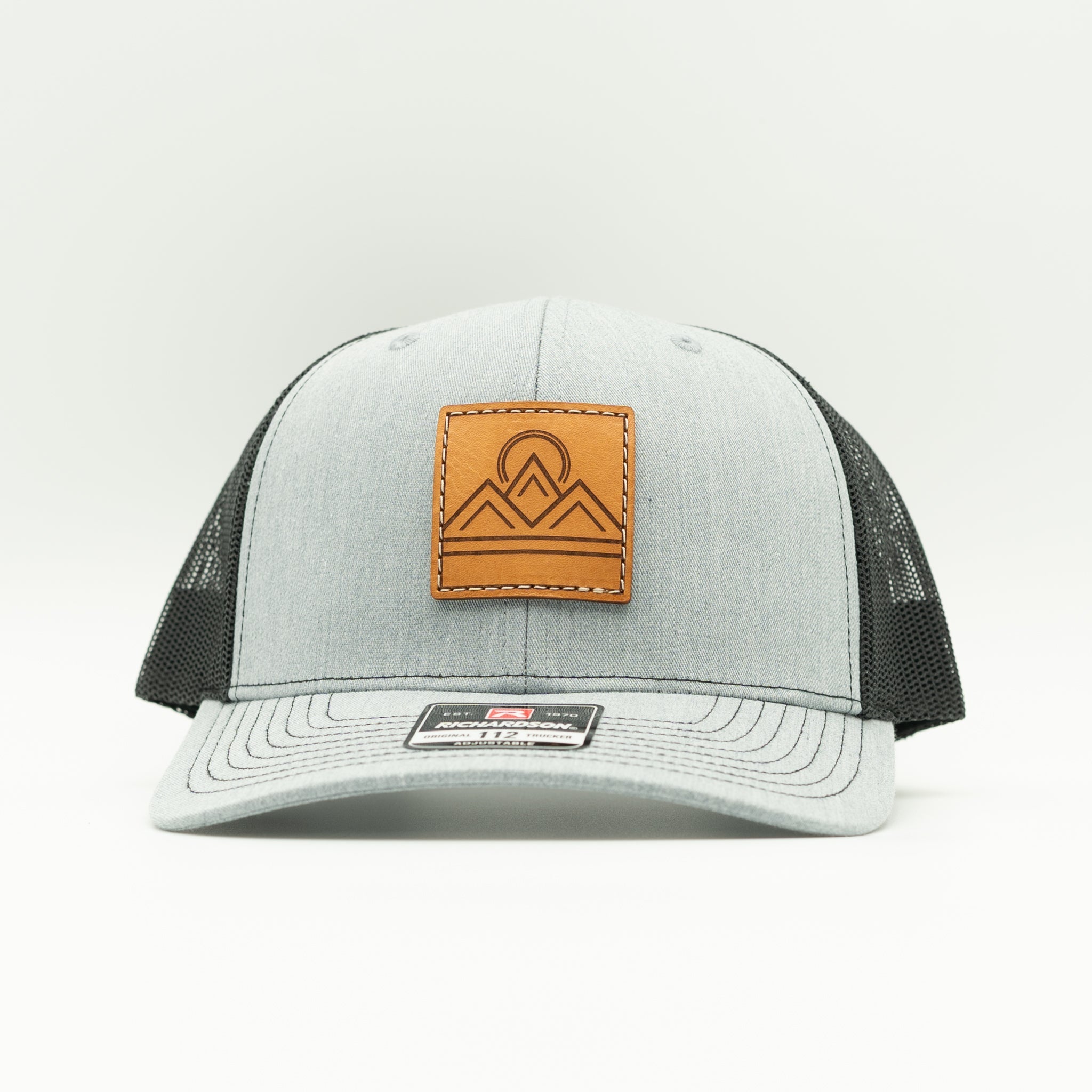Front view of Lunar Ridge heather grey and black Richardson 112 trucker hat with sewn leather mountain patch

Color: Heather Grey/Black
