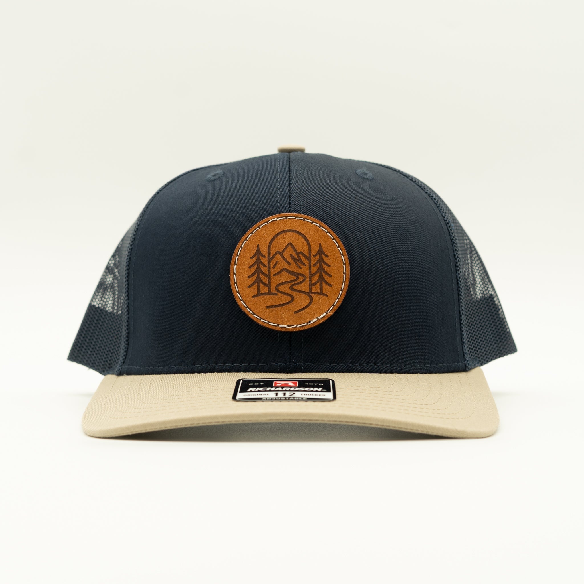 Front view of navy and khaki Richardson 112 The Passage trucker with round engraved leather patch.