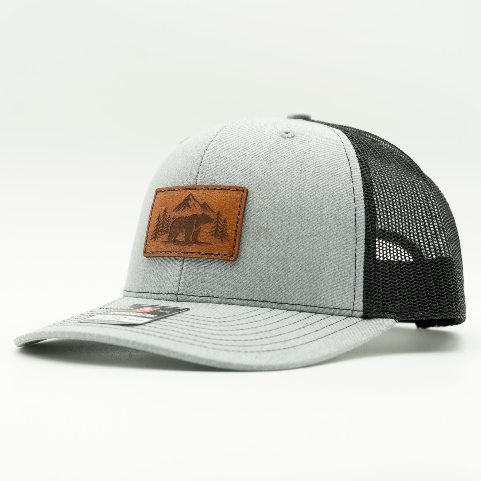 Side view of Bearline Peak leather patch hat on heather grey and black Richardson 112, highlighting veg tan leather patch, mid profile fit, and mesh back.

Color: Heather Grey/Black