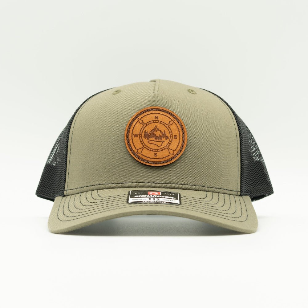 Loden and black Richardson 112FP five panel trucker, front view, round compass leather patch sewn on real veg-tan leather.