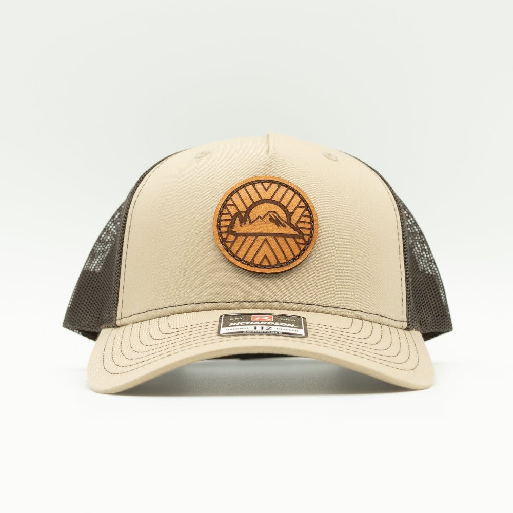 Front view of khaki/coffee Richardson 112FP hat with sewn Mosaic Sunset full-grain leather patch and seamless trucker front.

Color: Khaki/Coffee