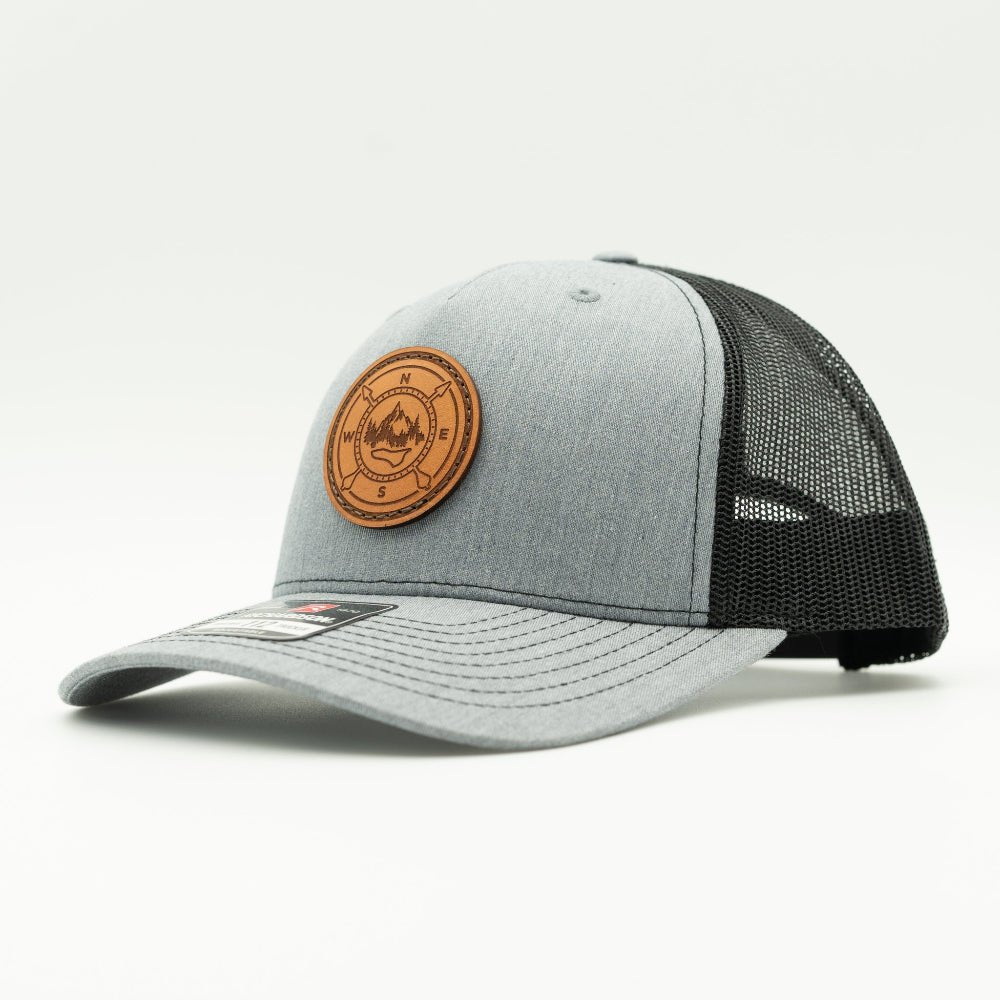 Heather grey and black Richardson 112FP compass leather patch hat, side angle, mid profile mesh back trucker.