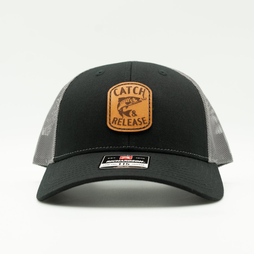 Front view of black and grey Richardson 115 low profile trucker hat with Catch & Release leather patch and curved visor.

Color: Black/Charcoal