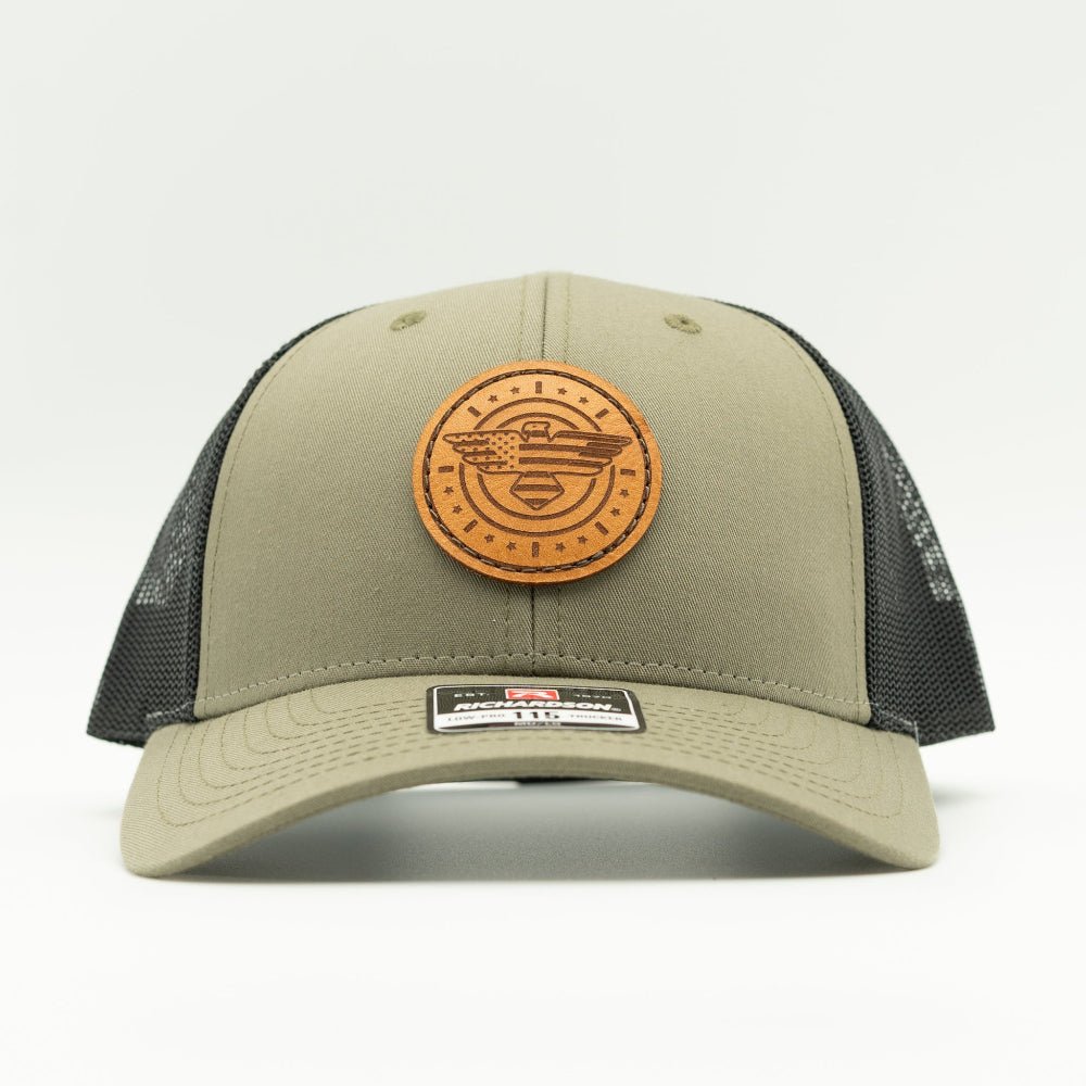 Front view of loden and black Richardson 115 low profile trucker hat with round American Eagle and flag leather patch, curved visor, and black mesh back.

Color: Loden/Black