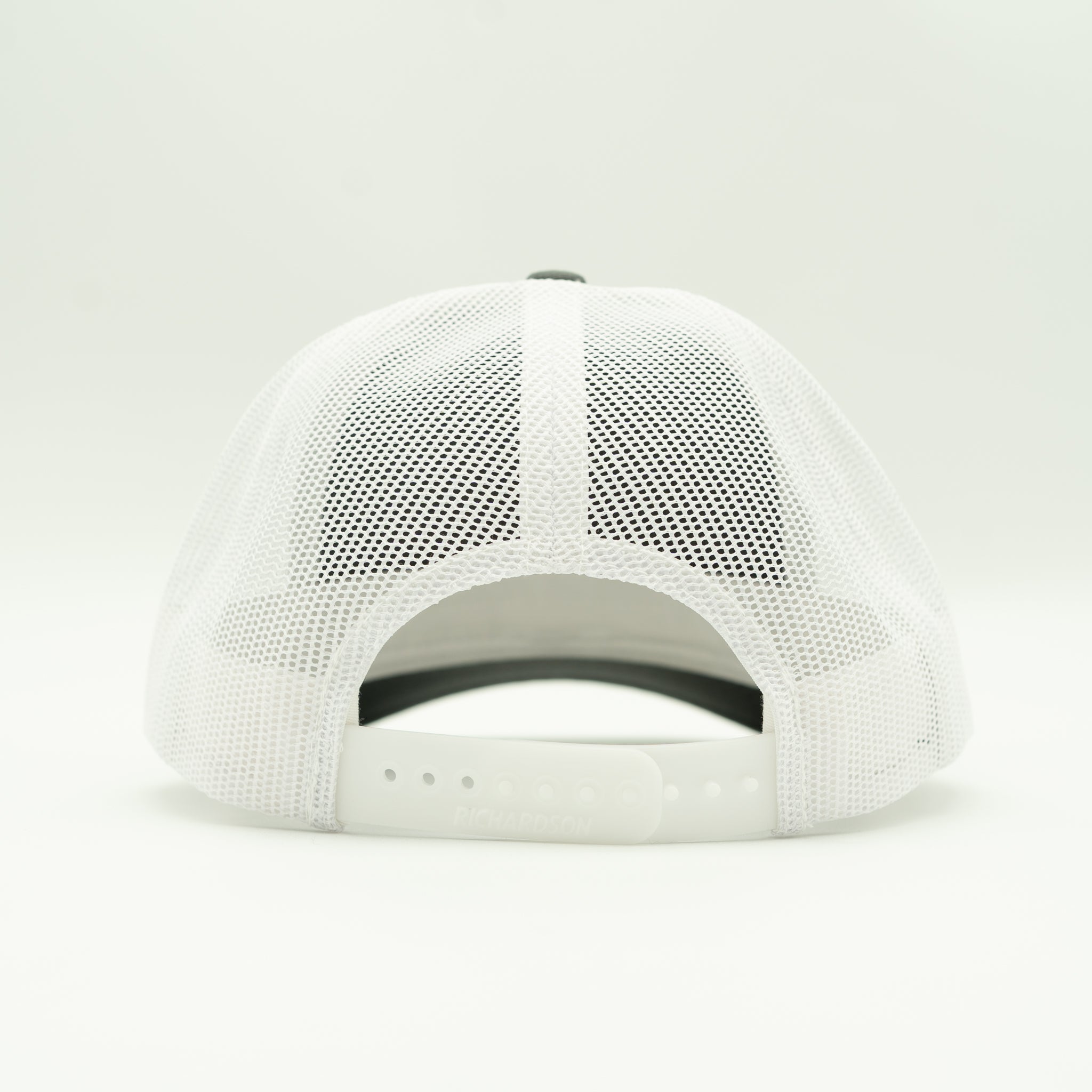 Back view black/white Solo Palm hat, bright white mesh and snapback closure on a men’s leather patch palm tree trucker cap.

Color: Charcoal/White