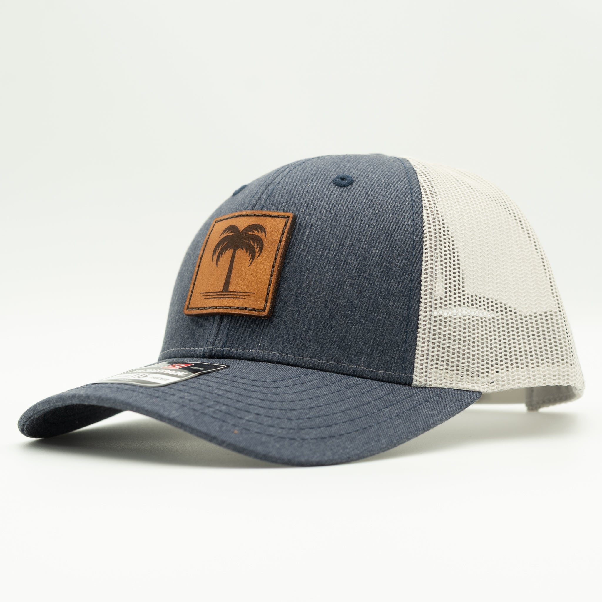 Heather navy and grey Solo Palm leather patch hat, Richardson 115 low profile trucker side view with blue crown and light mesh back.