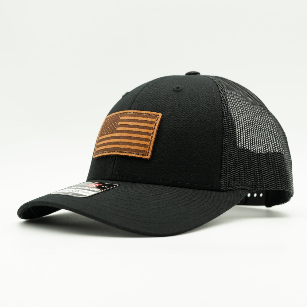 Side view of the Black American Flag Hat, showing the sleek black mesh back and snapback closure, with the American Flag leather patch visible from the side.

Color: Solid Black