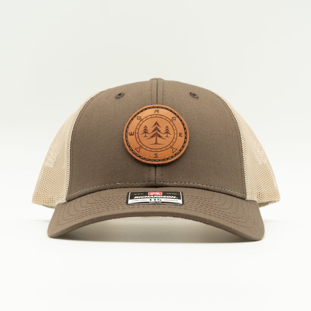 A brown and beige trucker hat with a circular leather patch on the front, photographed against a clean white background.

Color: Brown/Khaki