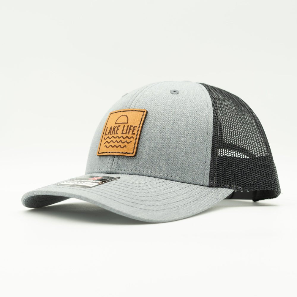Side view of Lake Life leather patch hat on heather grey and dark charcoal Richardson 115, showing shallow fit, leather patch, curved bill, and breathable mesh back.

Color: Heather Grey/Charcoal