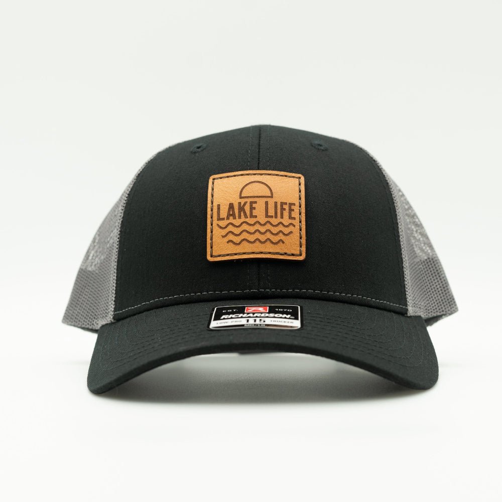 Front view of Lake Life leather patch hat on black and charcoal Richardson 115 low profile trucker, showing veg tanned leather patch, curved bill, mesh back, and snapback.

Color: Black/Charcoal
