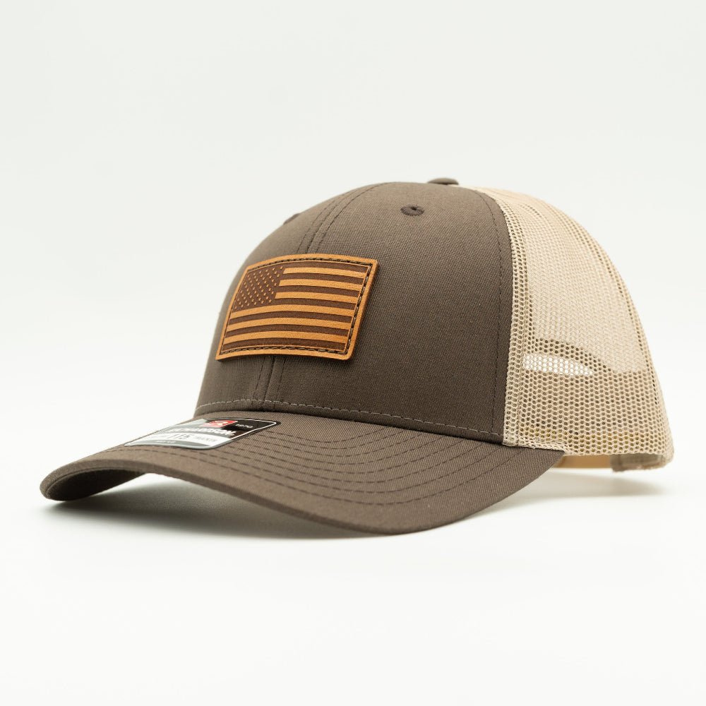 Side view of the Brown/Khaki American Flag Hat, showcasing the khaki mesh back and adjustable snapback closure, with the American Flag leather patch visible from the side.

Color: Brown/Khaki