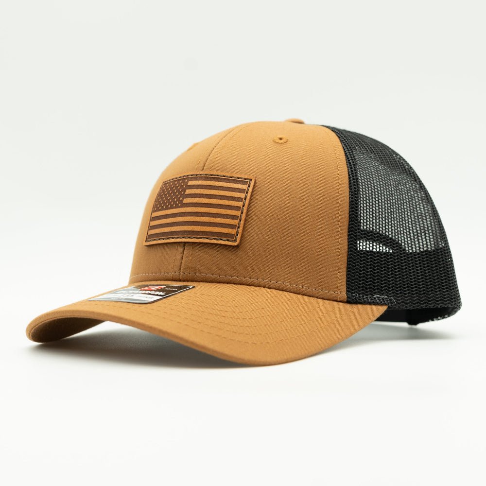 Side view of the Caramel/Black American Flag Hat, showcasing the black mesh back and snapback closure, with the American Flag leather patch visible from the side.

Color: Caramel/Black