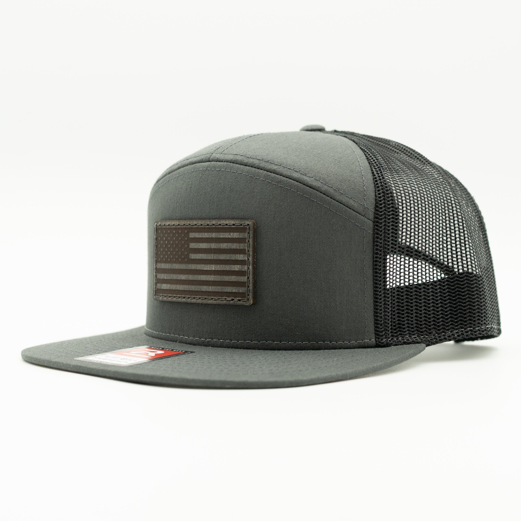 Charcoal and black Richardson 168 flat bill trucker hat with charcoal American Flag leather patch, side view highlighting high crown and mesh back.

Color: Charcoal/Black 168 (OSFM)