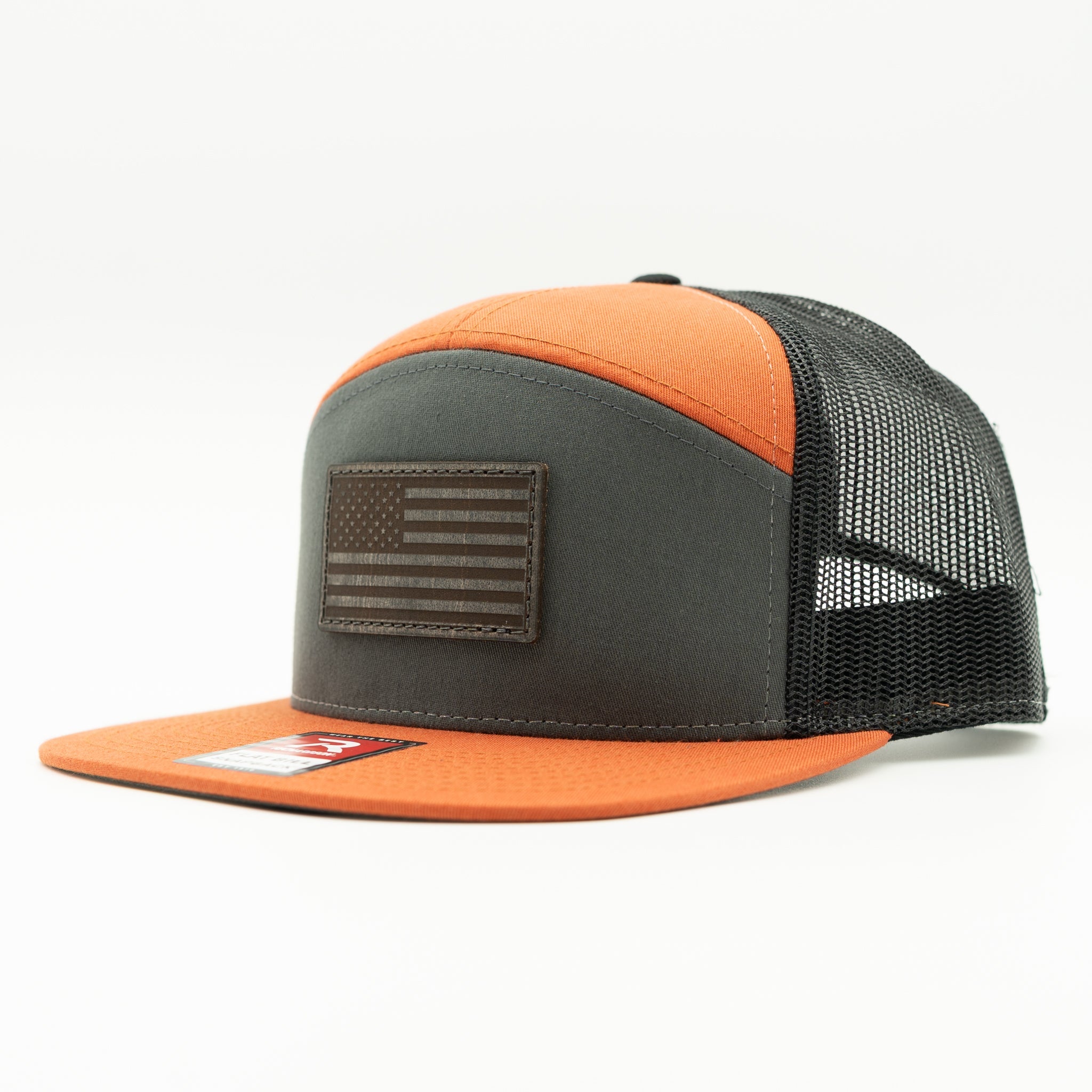 Charcoal, orange, and black Richardson 168 flat bill trucker hat with charcoal American Flag leather patch, side view highlighting seven panel crown and mesh back.

Color: Charc/Orange/Black 168 (OSFM)