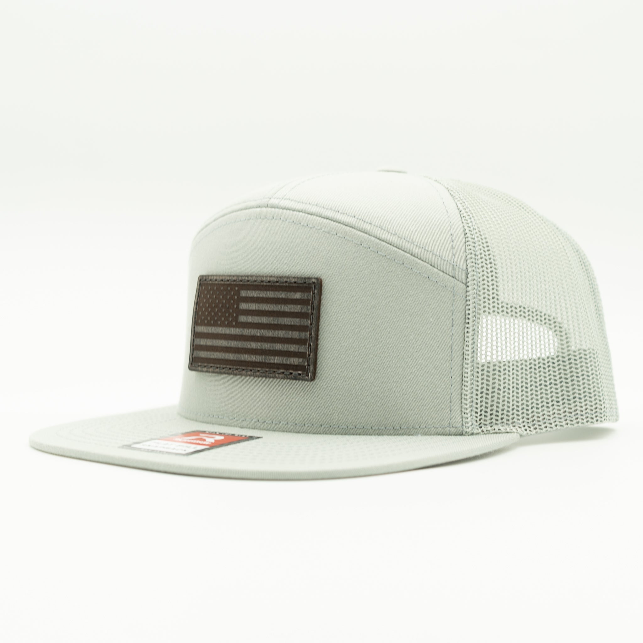 Quarry Richardson 168 flat bill trucker hat with charcoal American Flag leather patch, side view highlighting seven panel construction and mesh back.

Color: Quarry 168 (OSFM)