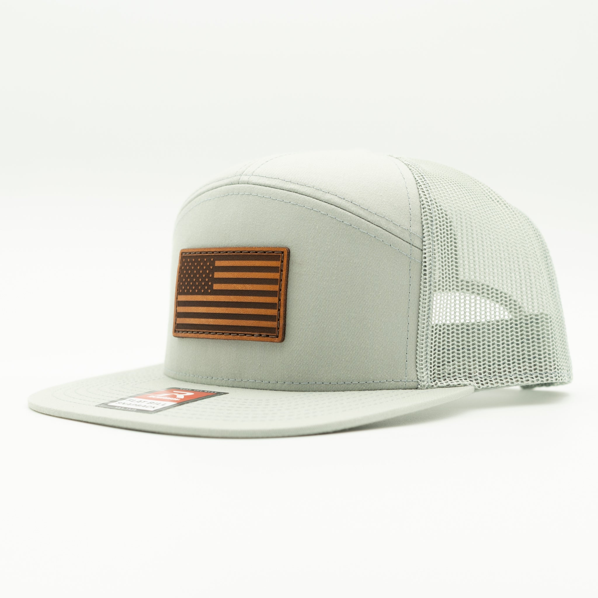 Quarry gray Richardson 168 seven panel flat bill trucker hat with light brown American Flag leather patch, side view showing high crown and mesh back.

Color: Quarry 168 (OSFM)