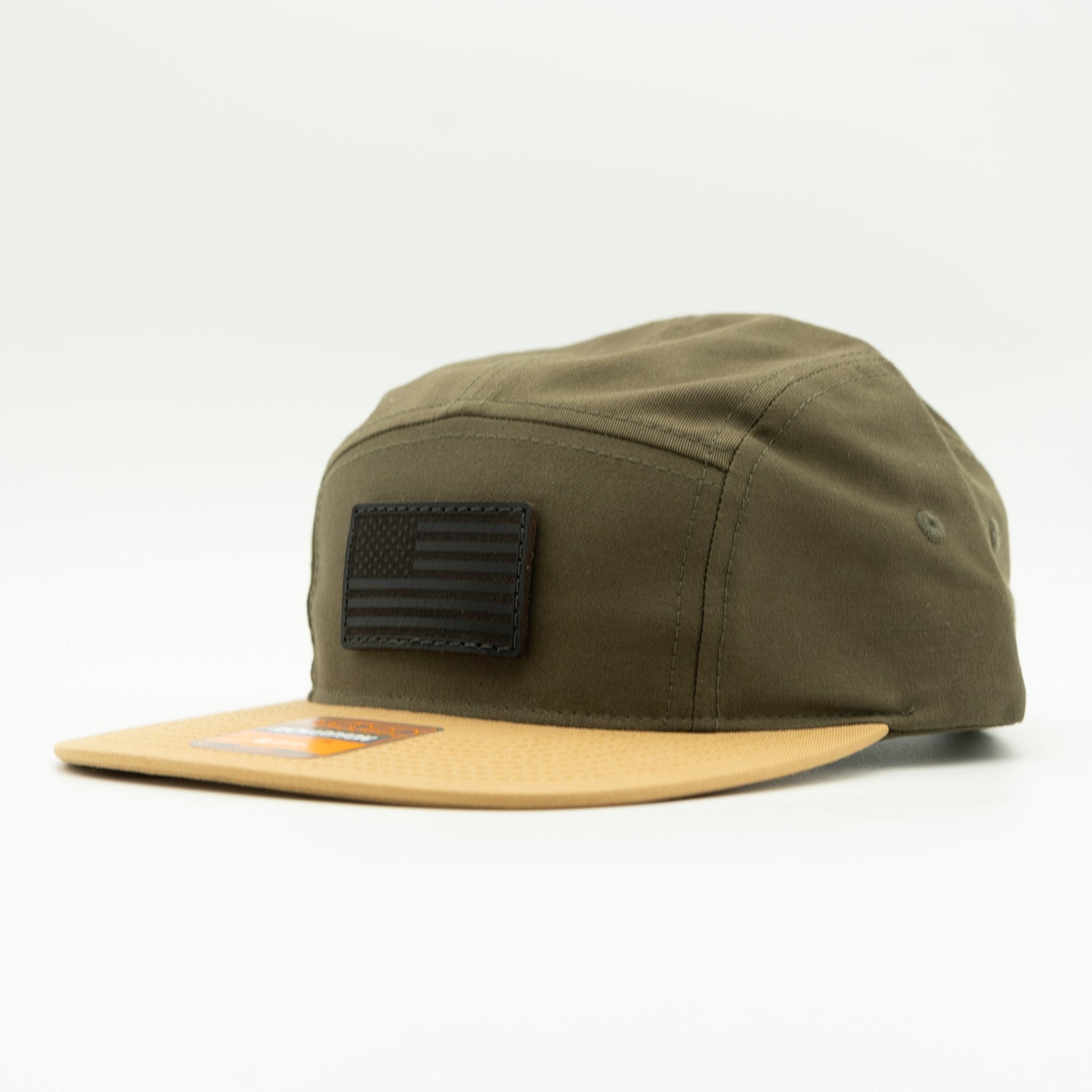 An olive green 5-panel cap with a tan flat brim and a black American flag patch on the front, photographed on a clean white background.

Color: Loden/Biscuit