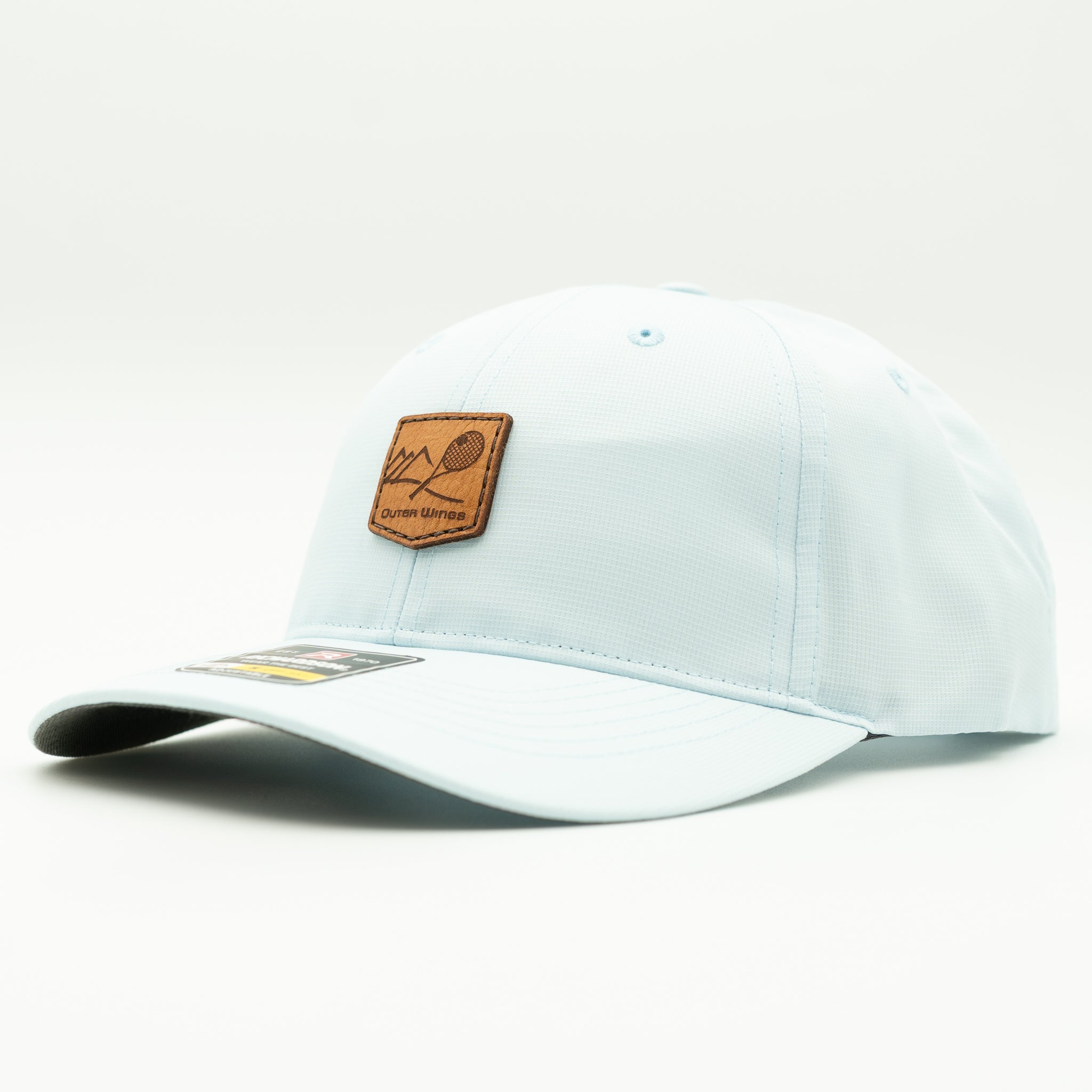 A light blue baseball cap with a brown leather patch on the front featuring a tennis racket graphic and the text 'Outer wings'.

Color: Soft Blue