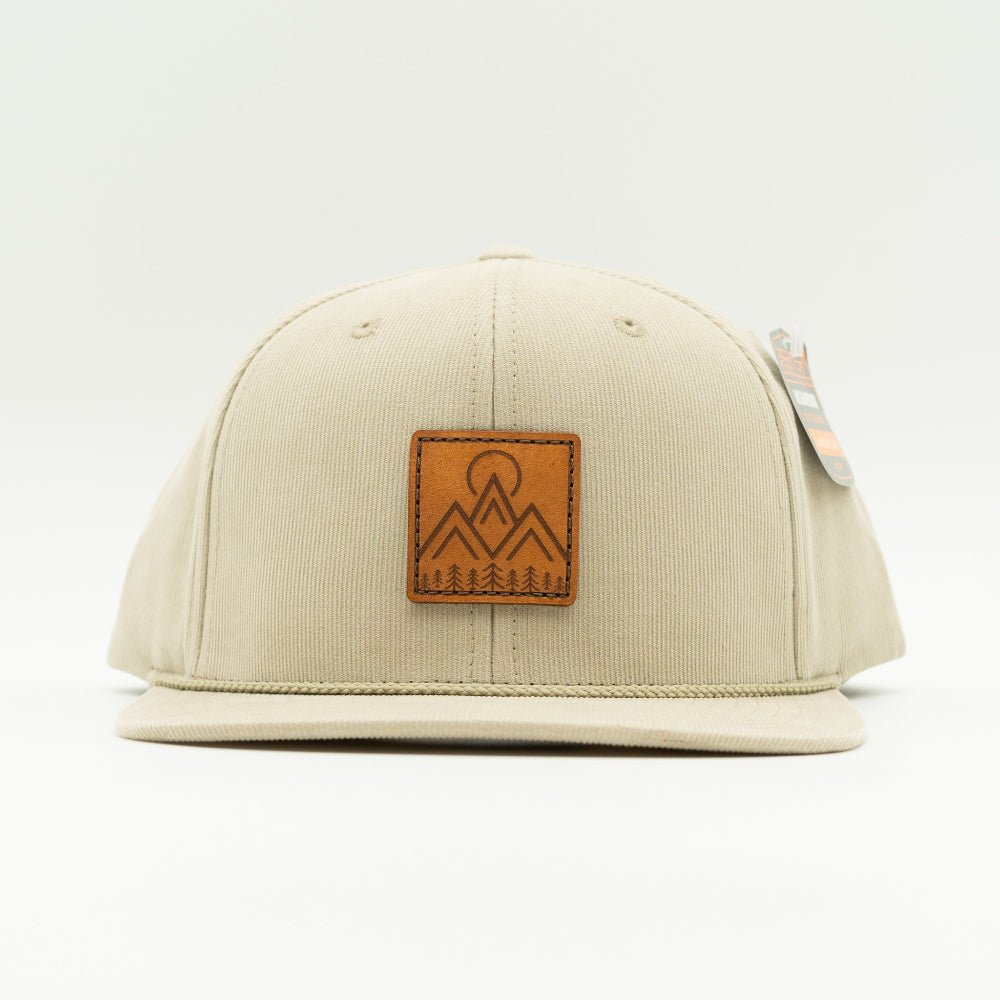 Front view of Moonlite Mountain leather patch rope hat on tan Richardson 253 corduroy, showing square mountain patch, vintage rope detail, and flat bill.

Color: Tan 253 (OSFM)
