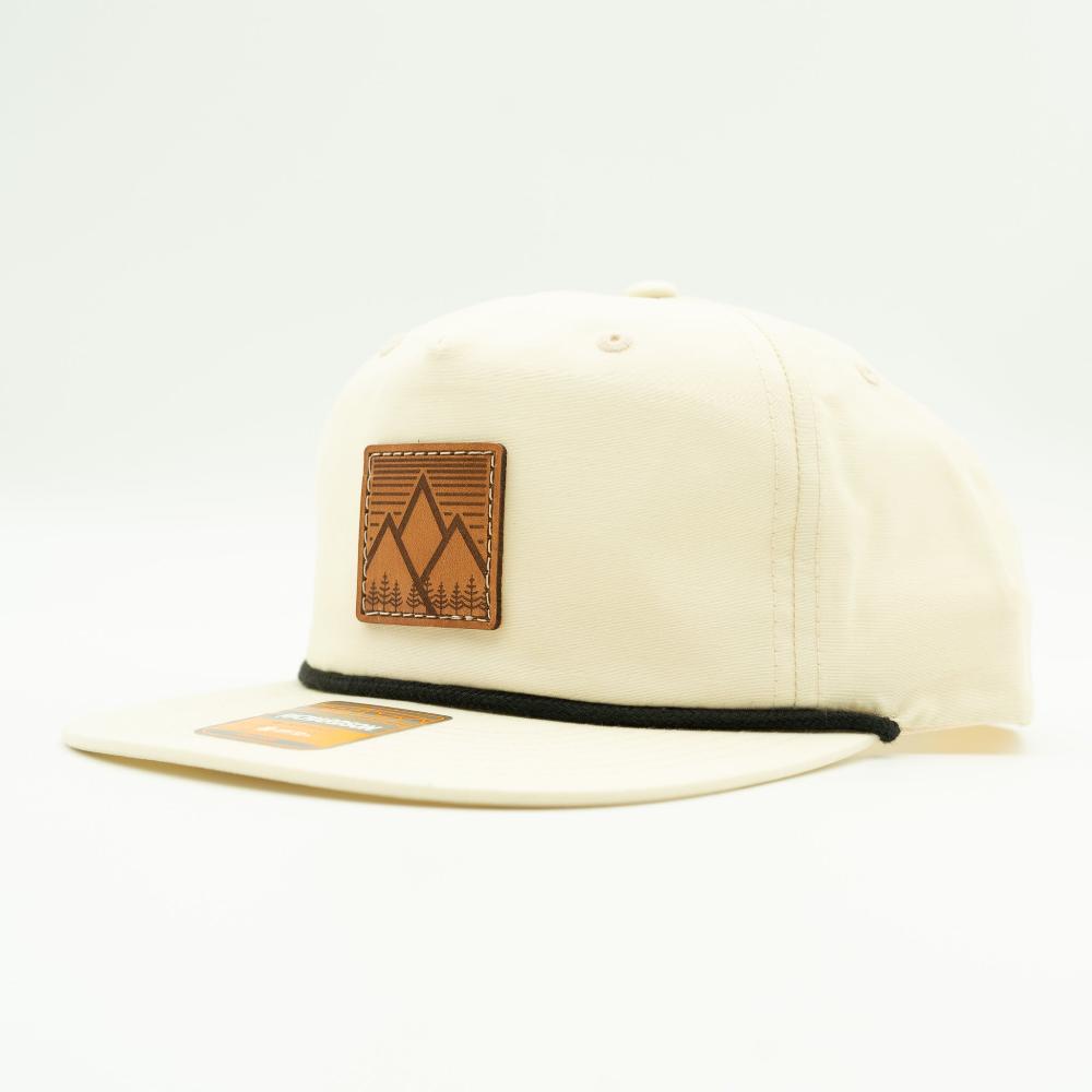Side view of birch Richardson 256 Mountain West rope hat, highlighting engraved leather mountain patch, full fabric crown, flat bill, and rope accent.