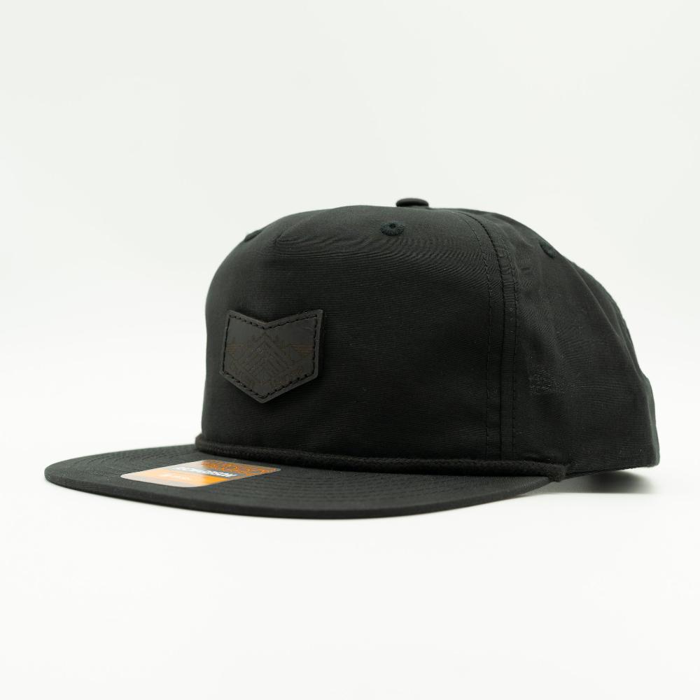 Side view of black Richardson 256 rope hat snapback, flat bill rope detail, low profile crown, sewn leather Midnight Mountain patch.