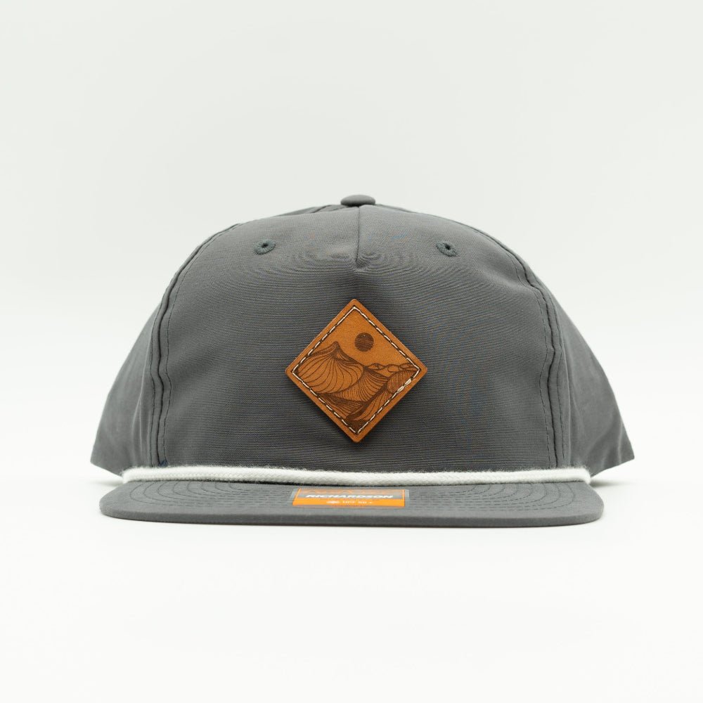 Front of charcoal Richardson 256 Desert Mountain rope hat with square leather mountain patch, rope detail, and UPF 50+ flat bill.

Color: Charcoal/White