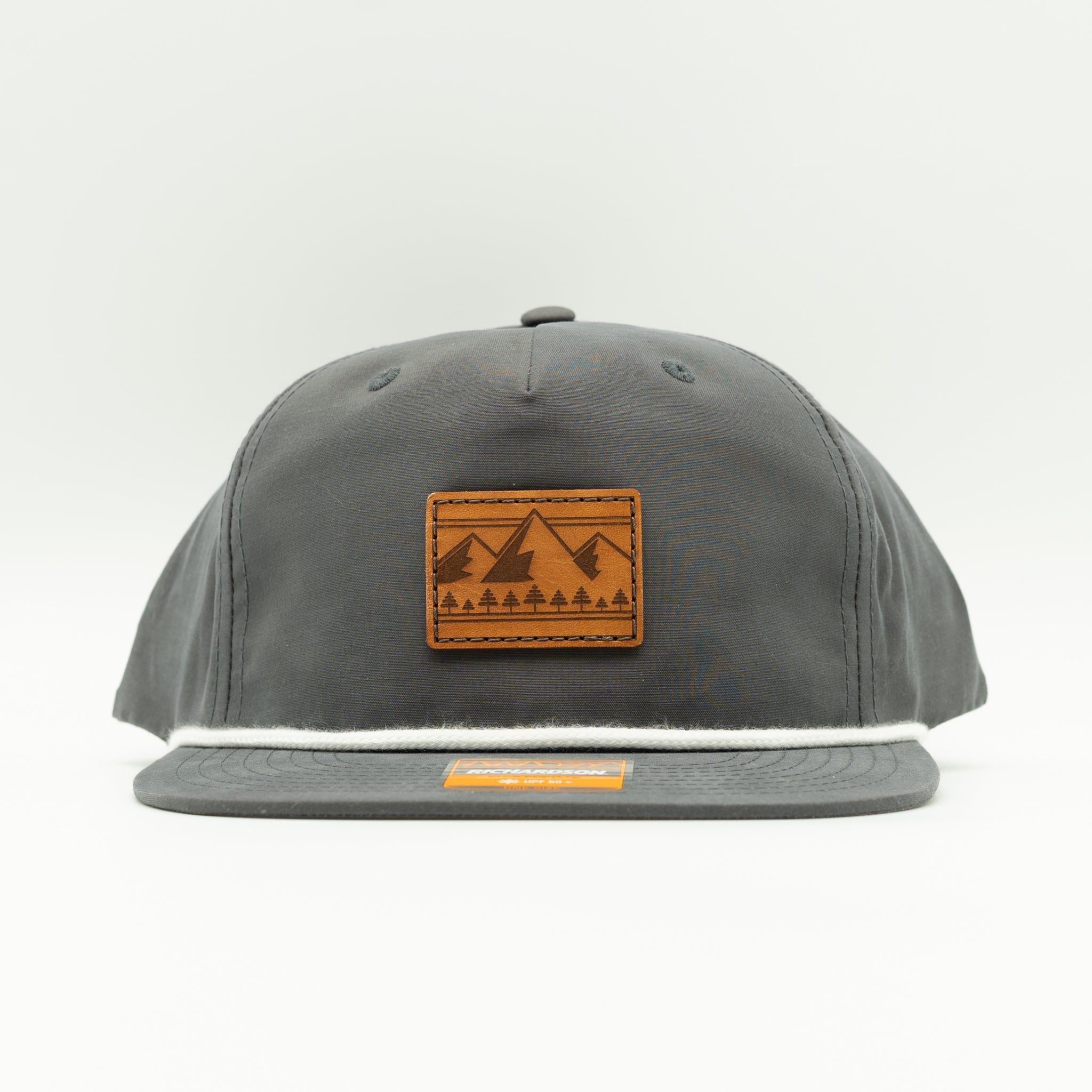 Front view of charcoal Richardson 256 Ridgeline rope hat with square leather mountain patch, flat bill and rope, lightweight cotton-nylon mountain hat.