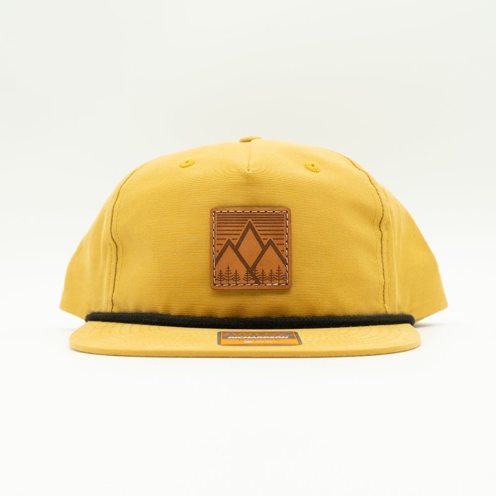 Front view of Mountain West leather patch rope hat on biscuit Richardson 256, warm golden crown with square mountain patch, flat rope bill, and low profile fit.