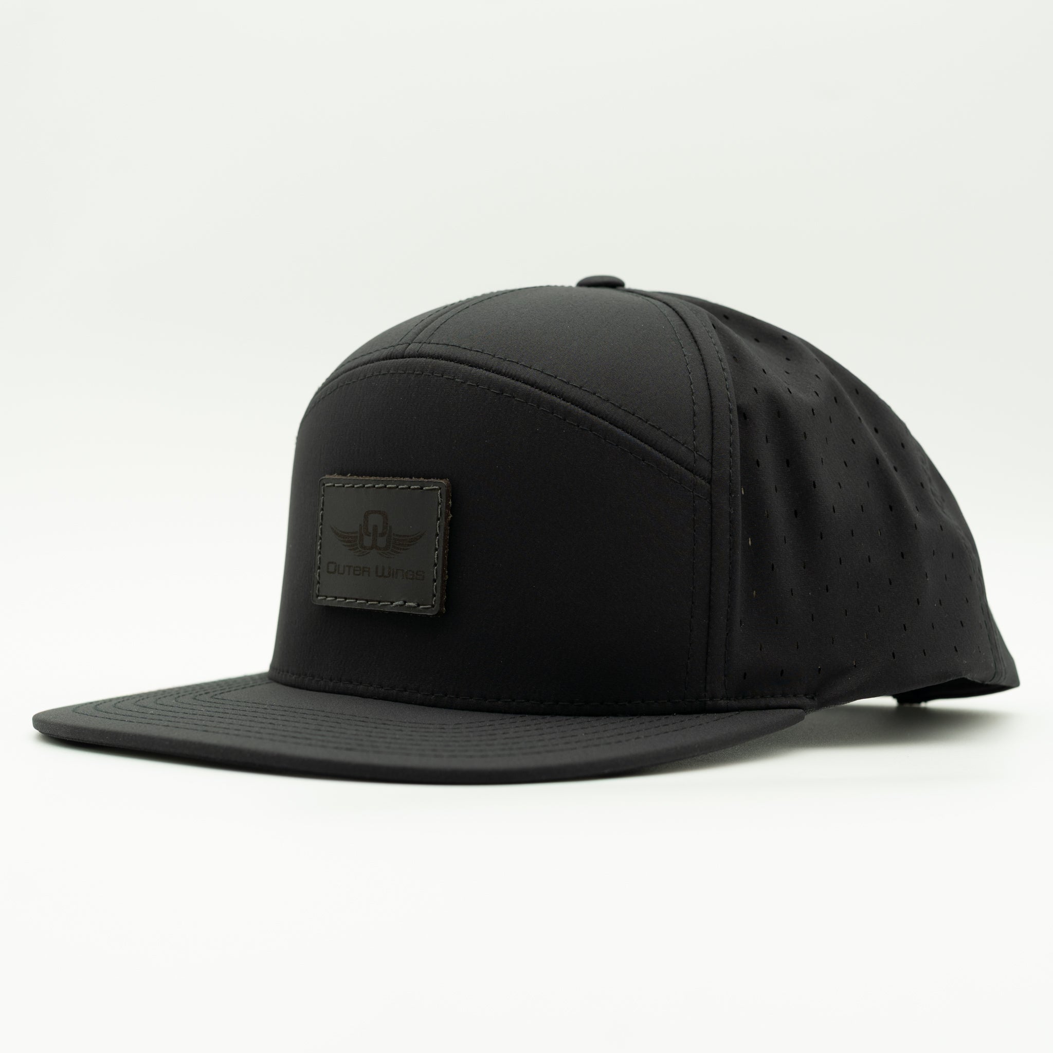 A black flat-brim baseball cap with a structured crown, perforated side panels, and a rectangular black leather patch on the front featuring a winged logo and the brand name 'Outer Wings'.

Color: Black