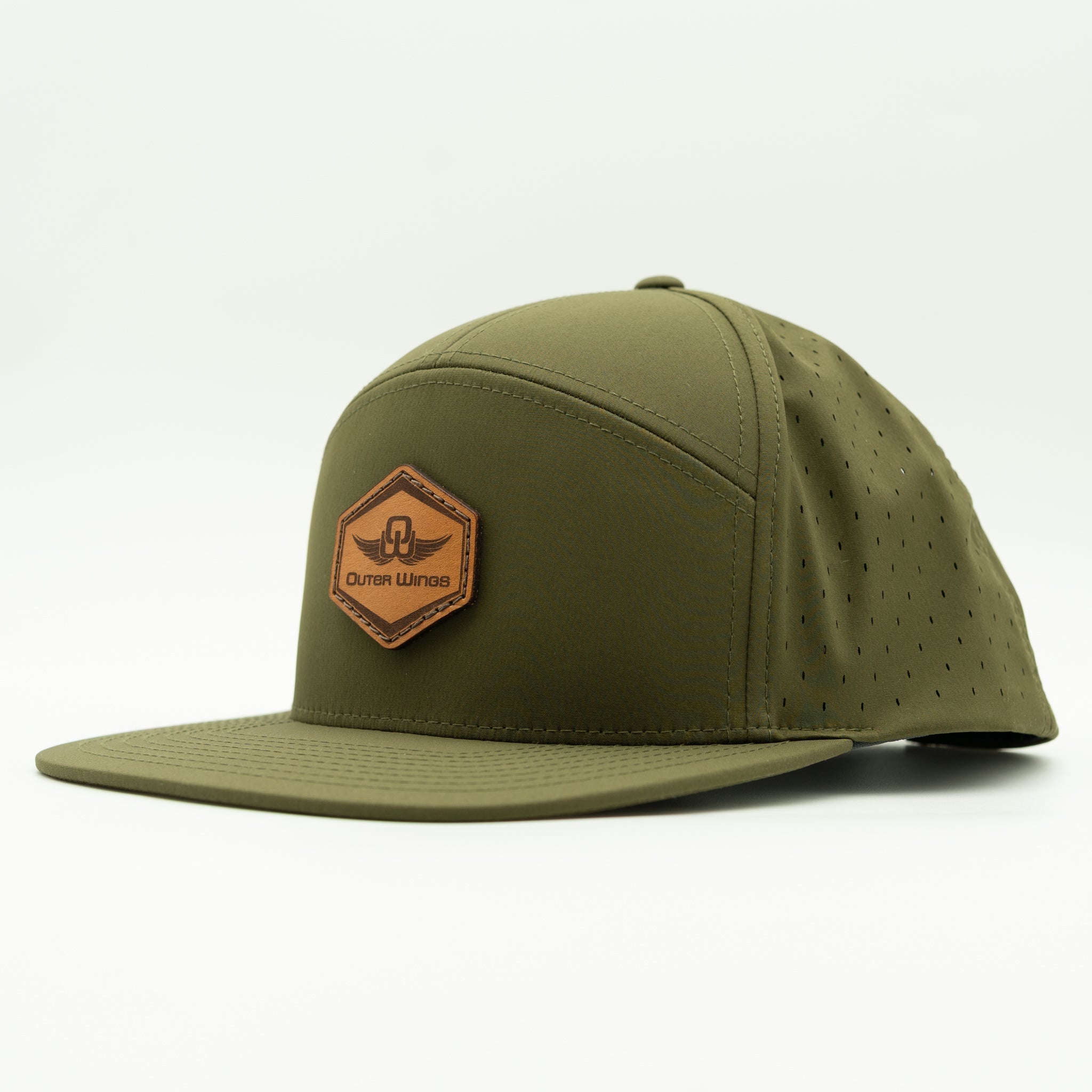 An olive green flat-brim cap with a brown leather patch on the front that reads 'Outer Wings'. The cap features a structured crown with subtle perforations on the side panels and a matching perforated brim, photographed on a clean white background.

Color: Olive