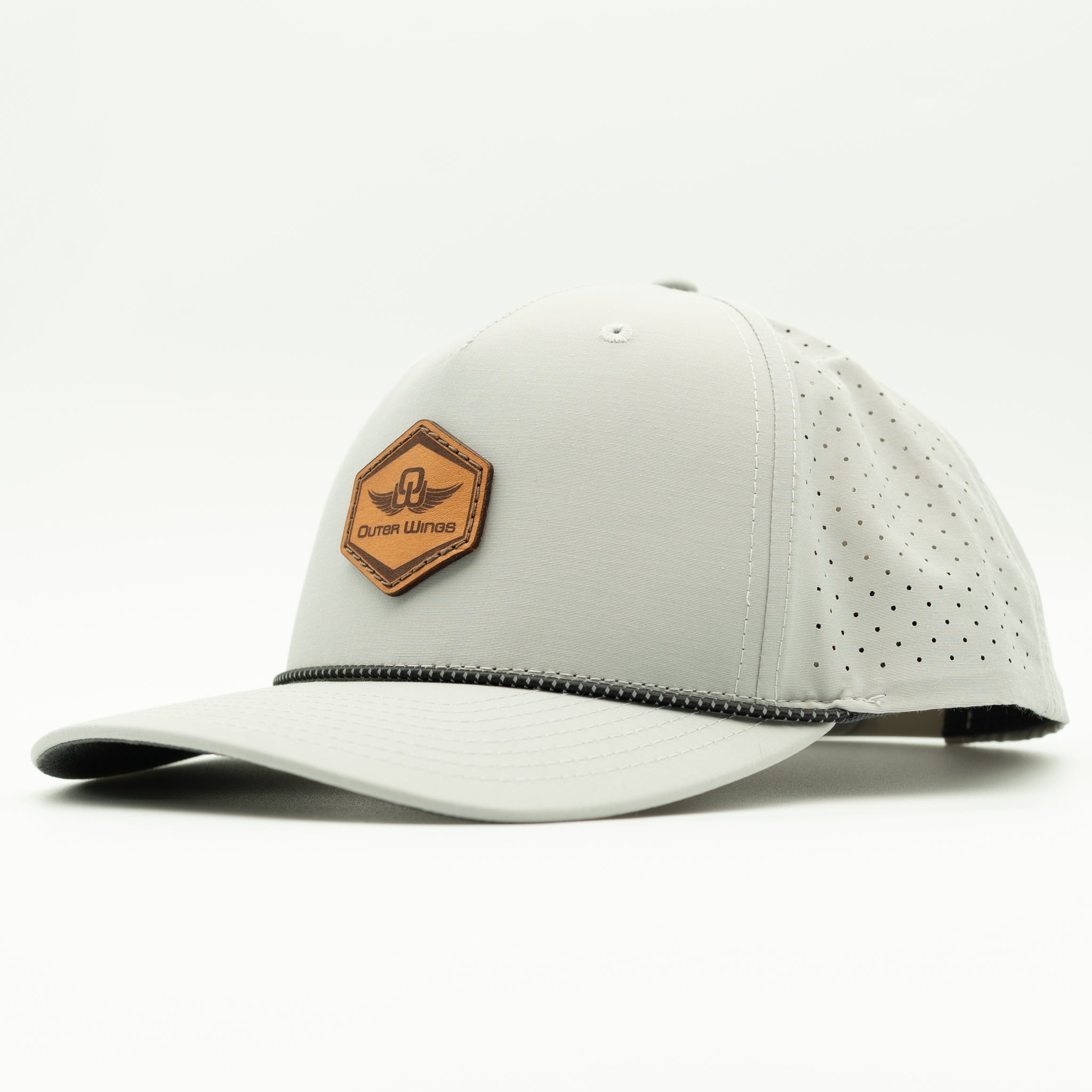 A light gray baseball cap with a brown hexagonal patch on the front that reads 'Outer Wings'. The cap features perforated side panels and a black stitched detail along the edge of the visor, set against a plain white background.

Color: Silver