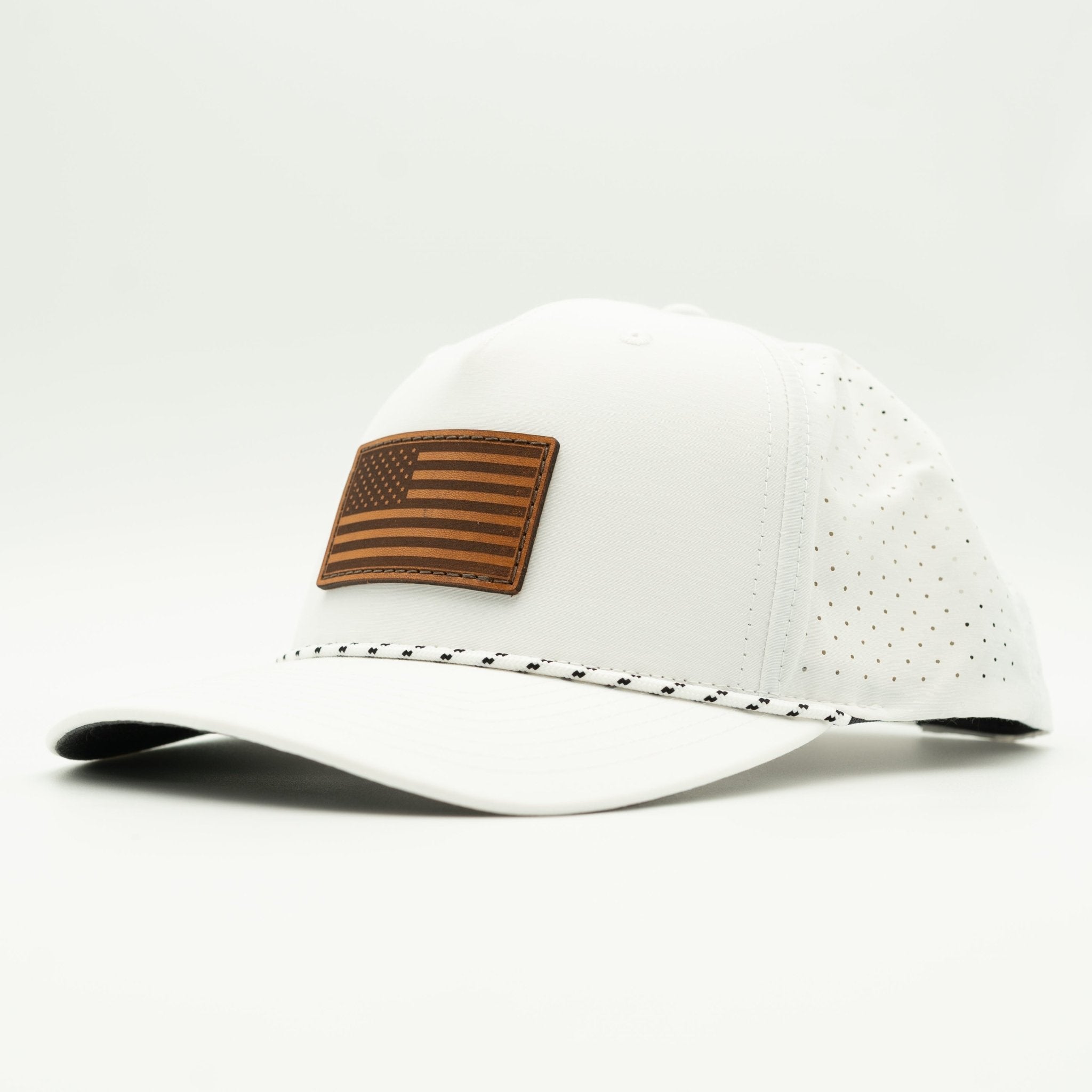 A white baseball cap with a brown leather American flag patch on the front and a perforated side panel, shown on a light gray background.

Color: White/Black