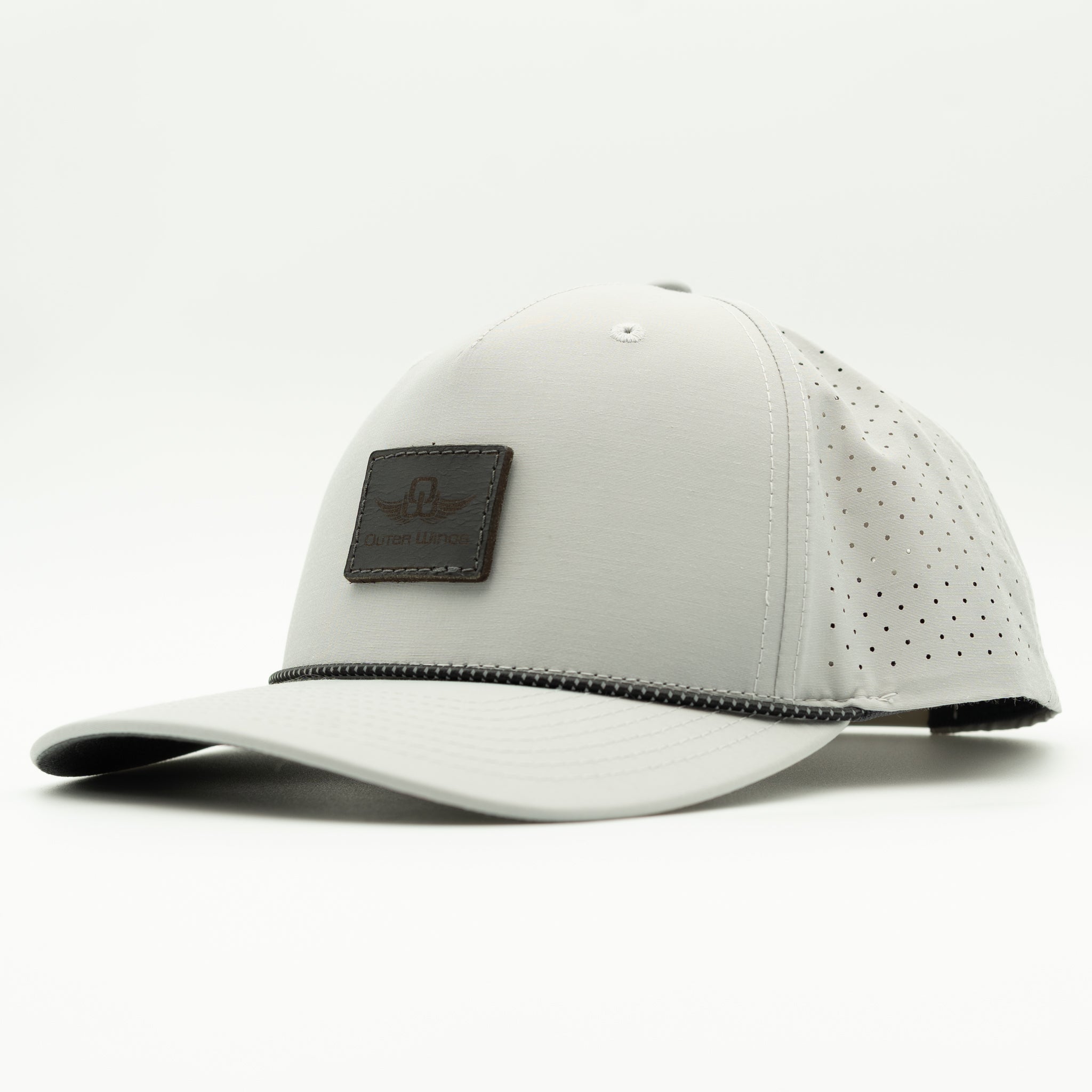 A light gray athletic cap with perforated side panels, a curved brim, and a dark Black rectangular patch on the front featuring a stylized logo and the text 'Outer Wings'.

Color: Silver