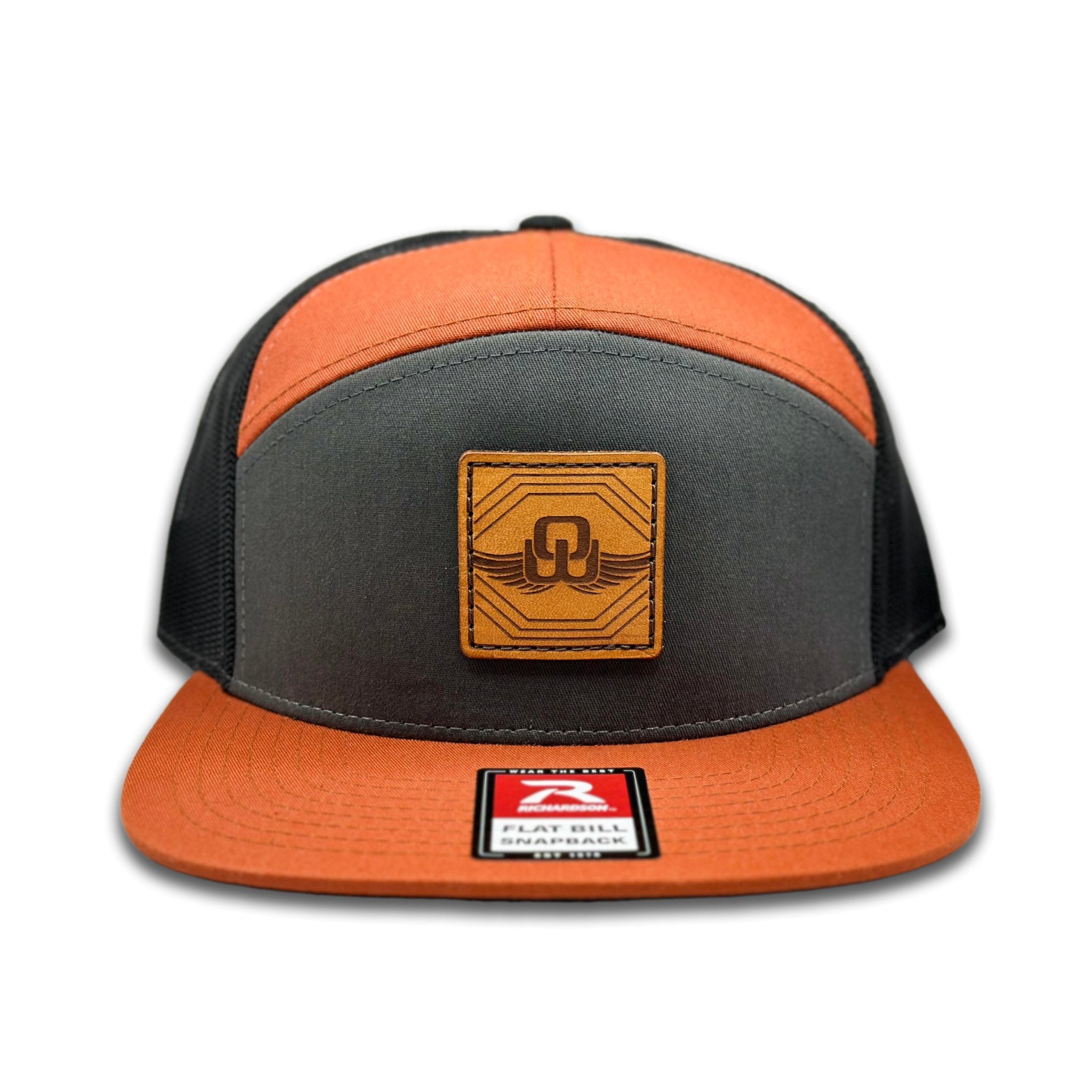 Front view of the Skybound Leather Patch Hat by Outer Wings in Charcoal/Burnt Orange/Black, featuring a high-profile Richardson 168 with a genuine leather patch of the Skybound design. Ideal for outdoor enthusiasts and casual wear.