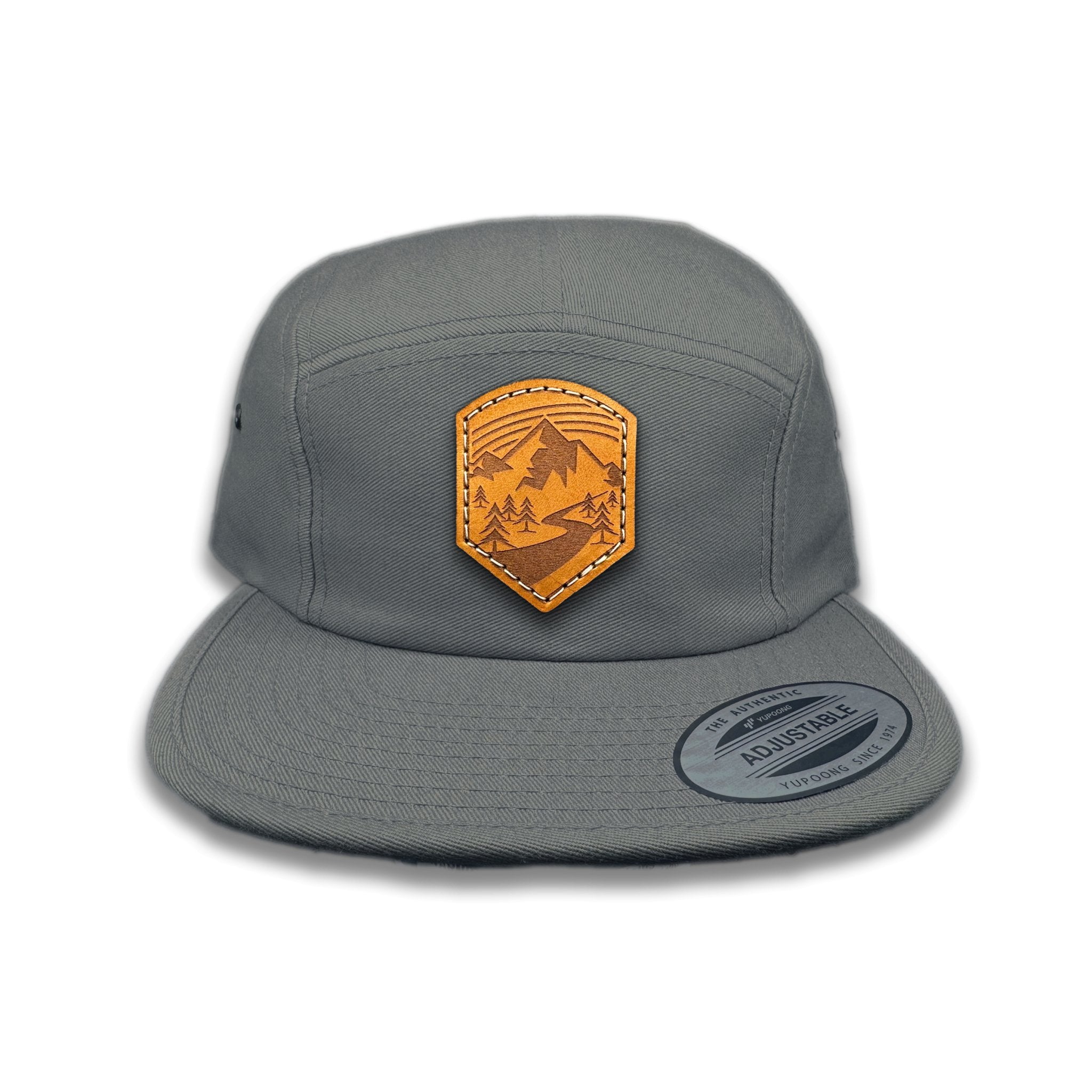 Front view of the Wanderlust Leather Patch Hat by Outer Wings in Dark Grey, crafted on a low profile Yupoong 7005 hat with a leather patch featuring a mountain trailhead design. Ideal for hiking and outdoor wear.