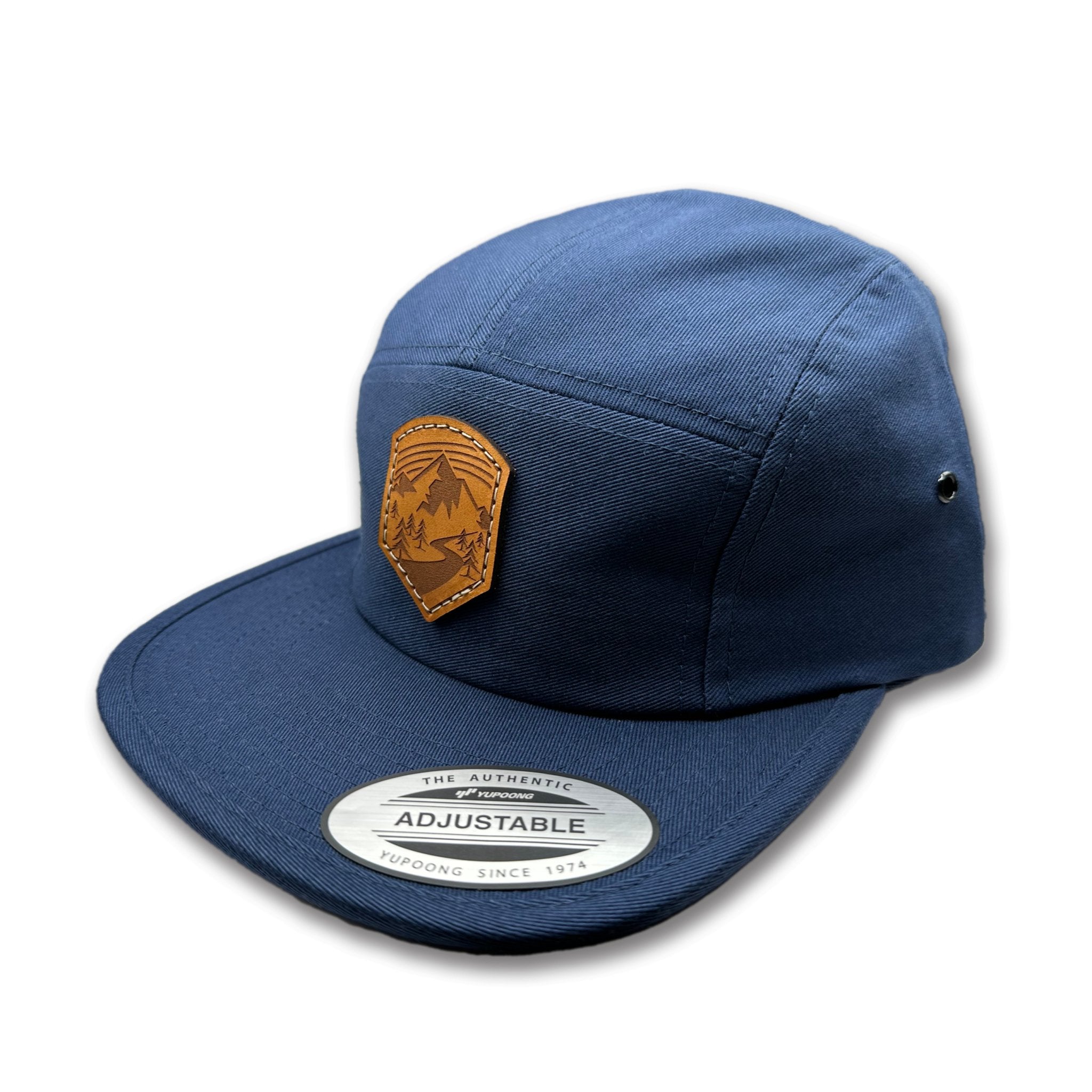 Side view of the Wanderlust Leather Patch Hat by Outer Wings in Navy, highlighting the structured design, flat bill, and adjustable strap closure. A durable and stylish custom leather patch hat for outdoor activities and casual wear.