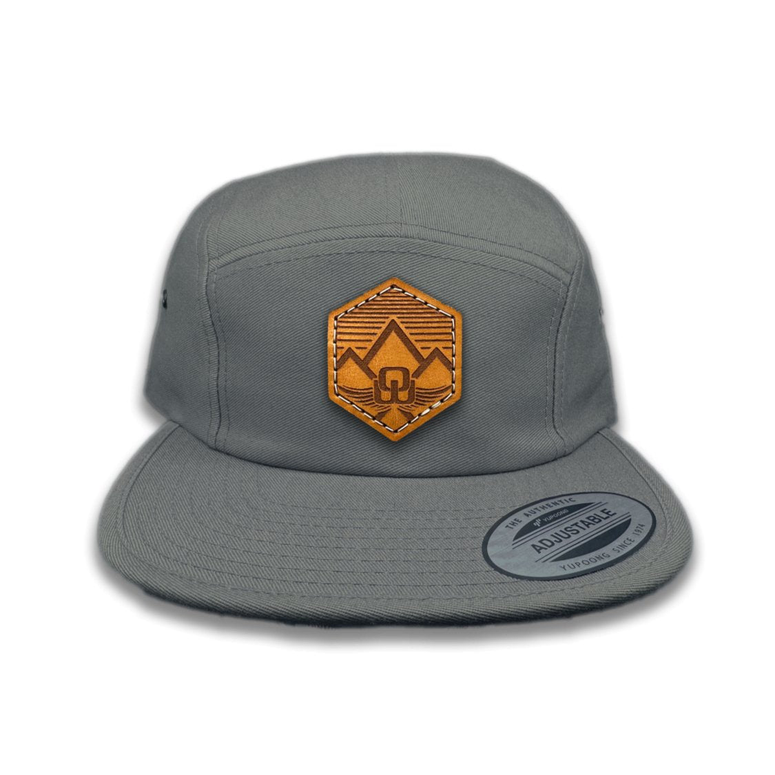 Front view of the Wingrest Leather Patch Hat by Outer Wings in Dark Grey, crafted on a low profile Yupoong 7005 hat with a laser-engraved leather patch featuring a modern mountain backdrop. Ideal for hiking and outdoor wear.